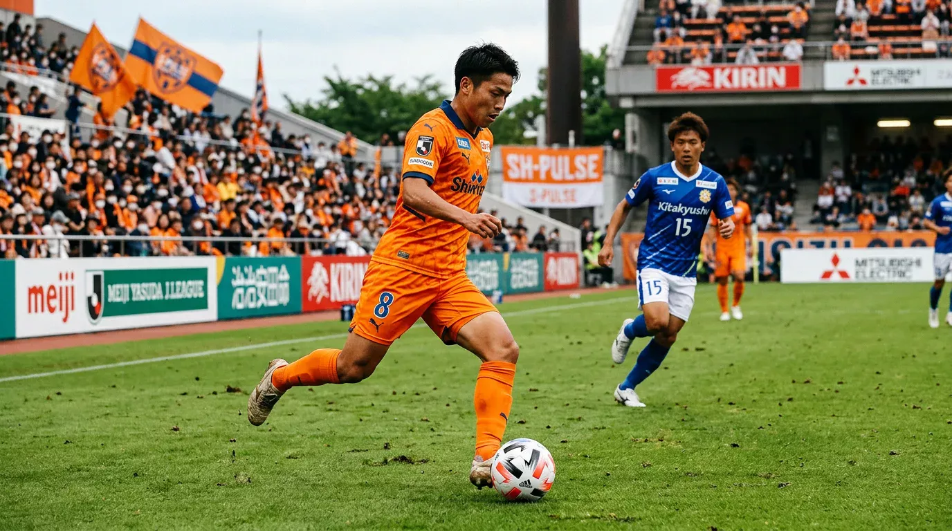 Jugador del Shimizu S-Pulse con camiseta naranja controlando el balón en el IAI Stadium Nihondaira
